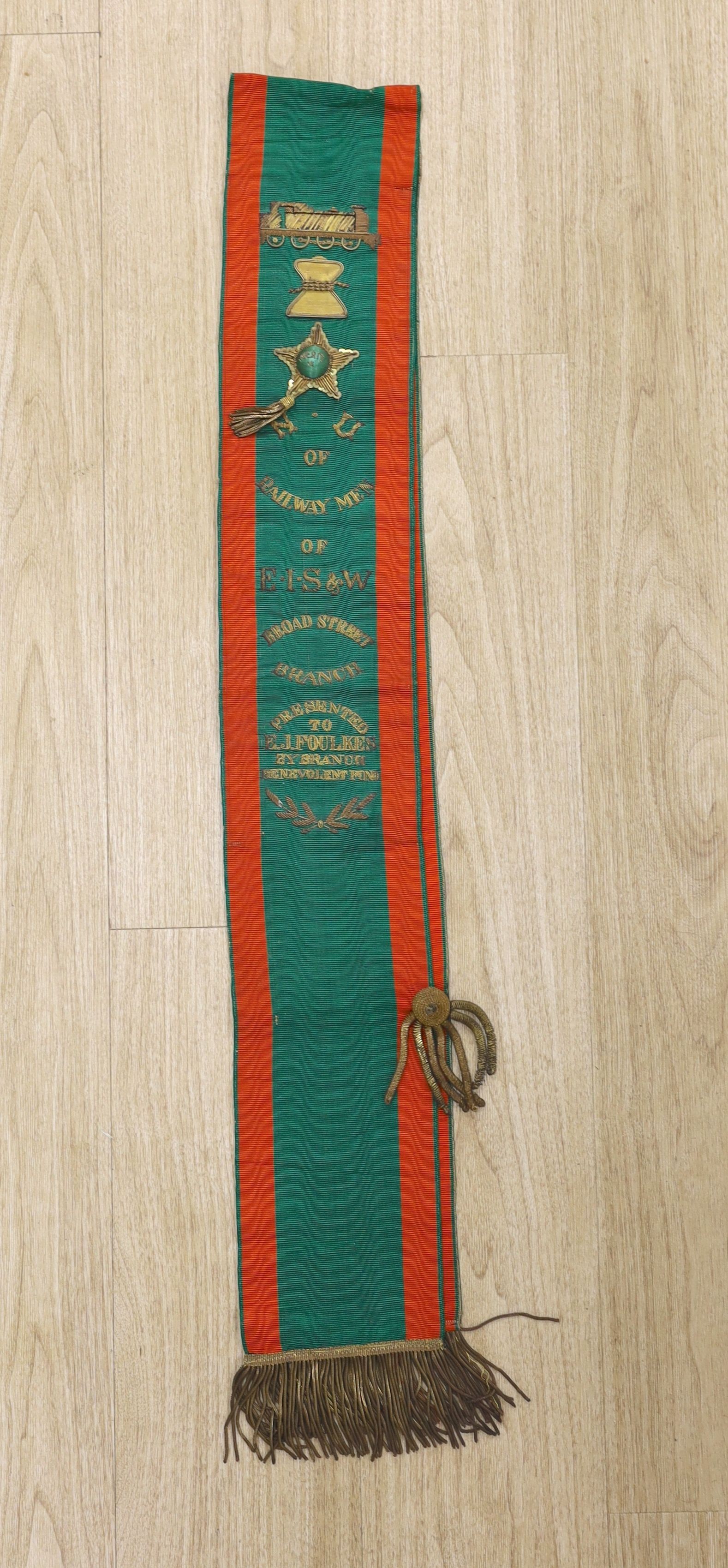 Railway Interest - A metal thread embroidered silk sash inscribed ‘Railway Men of E I S & W, Broad Street Branch - presented to E.J. Foulkes by branch benevolent fund’ - approx 190cm long